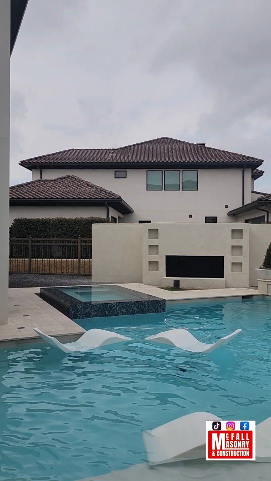 Outdoor living pool, spa and fireplace built by McFall Masonry in Frisco, Texas